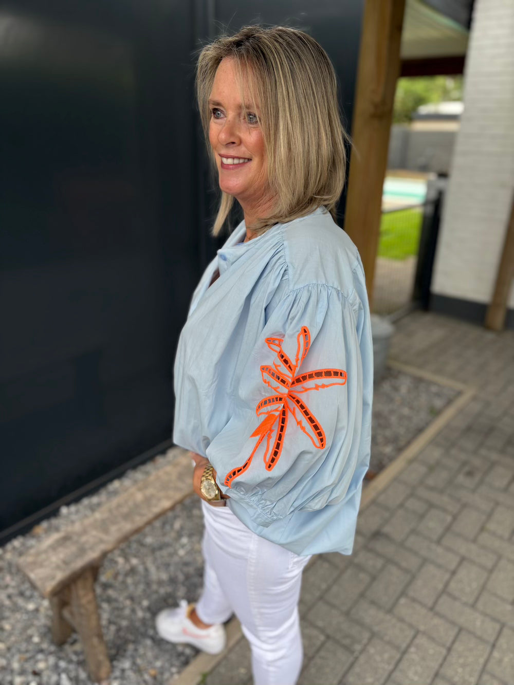Wijde blouse lichtblauw met neon bloem op de mouw